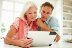 Man and woman sharing tablet to read.